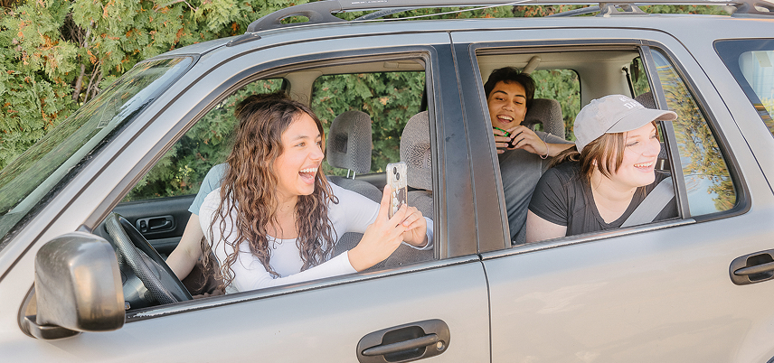 Friends in a car - laughing and looking outside.