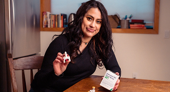 Person holding a naloxone nasal spray.