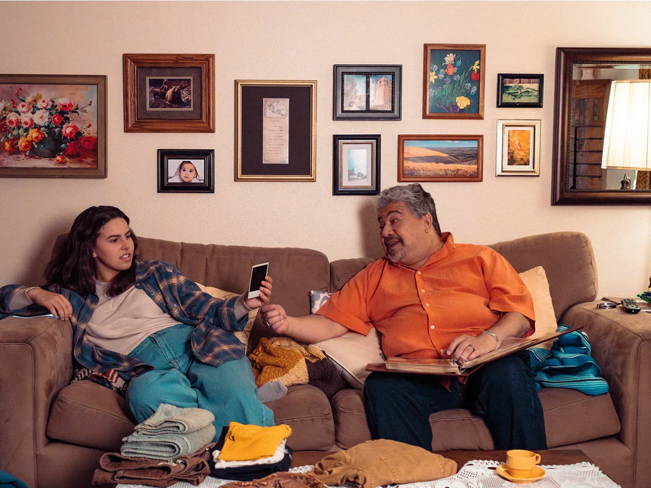Guardian shows photo to a teen, they are sitting on a couch.