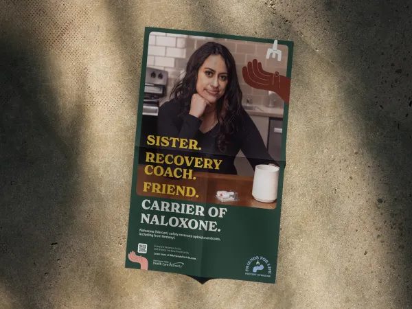 Image of a poster with a woman with long dark hair sitting at a table