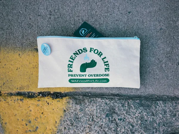 Image of a cream cloth zipper pouch with Friends for Life in dark green