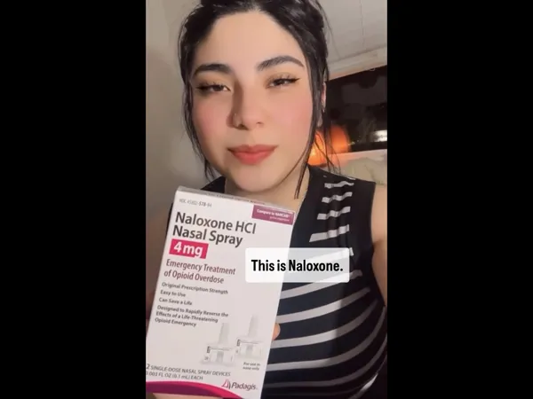 A person holding a box of naloxone nasal spray.