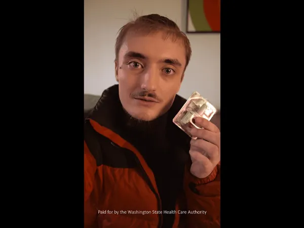 A person holding up naloxone nasal spray.
